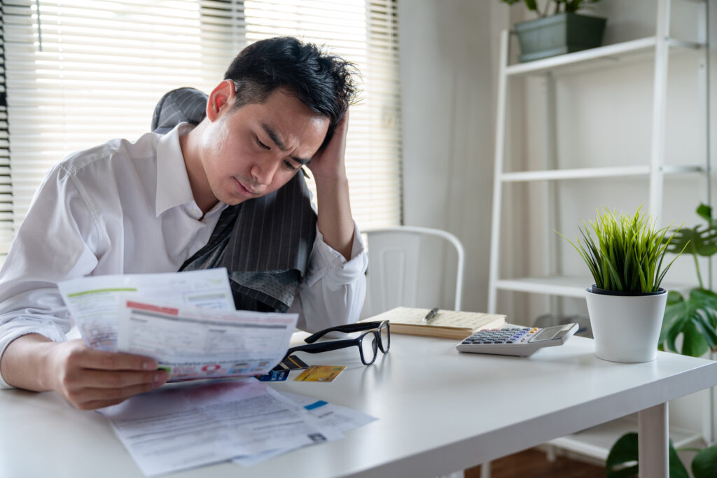 Stressed man reviewing tax documents – gig and contract worker payroll