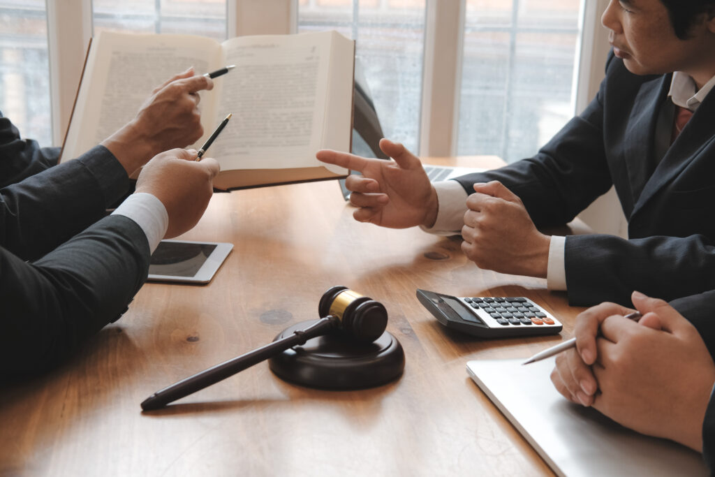 Business professionals reviewing documents and law books – gig and contract worker payroll