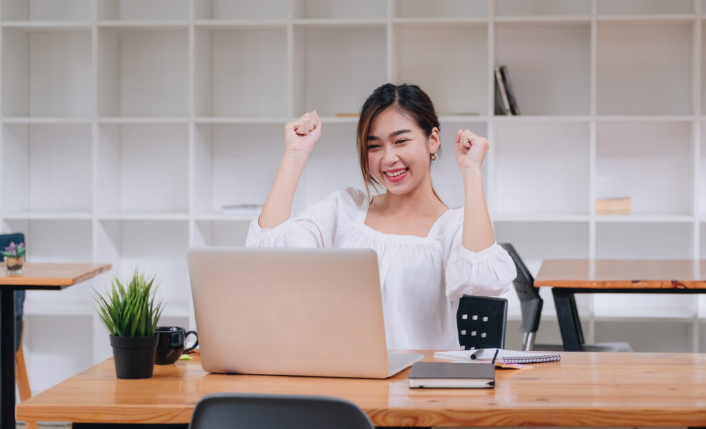 Happy female employee celebrating a win, reflecting the success of an employer branding strategy