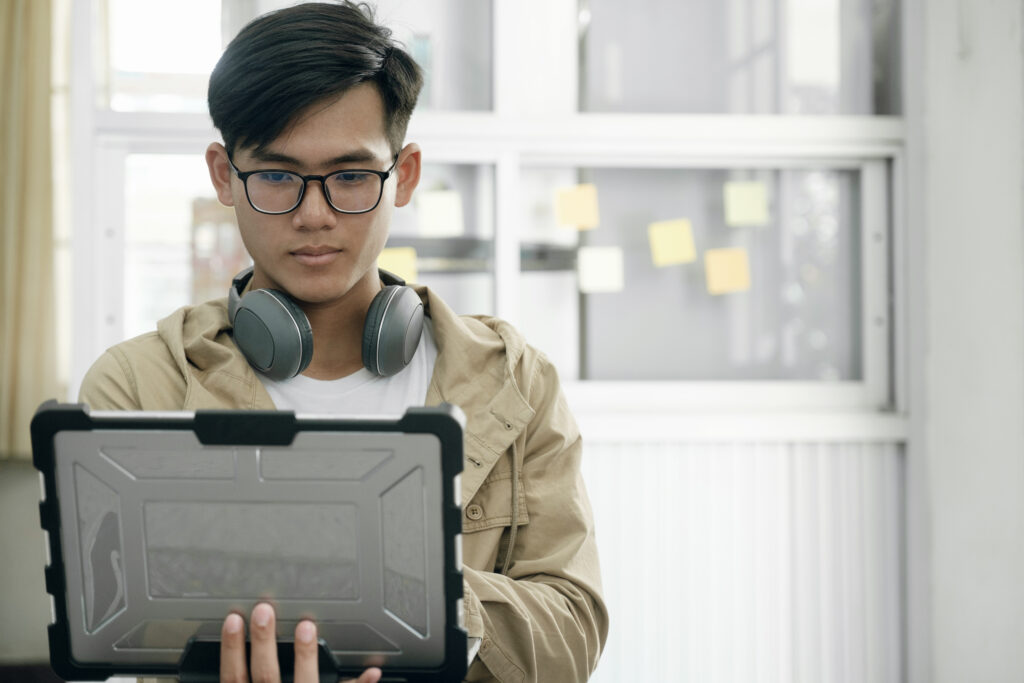Young professional adapting to technology, reflecting hiring for potential vs experience in Malaysia.
