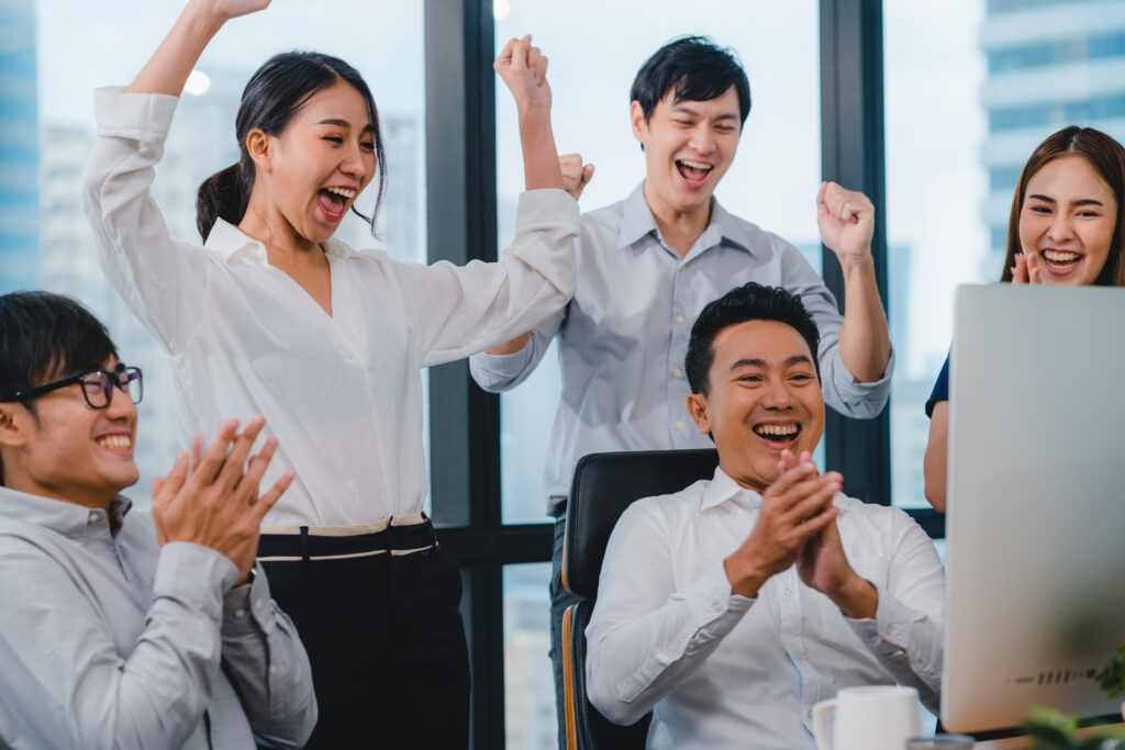 Office team celebrating successful project completion in a modern workplace.