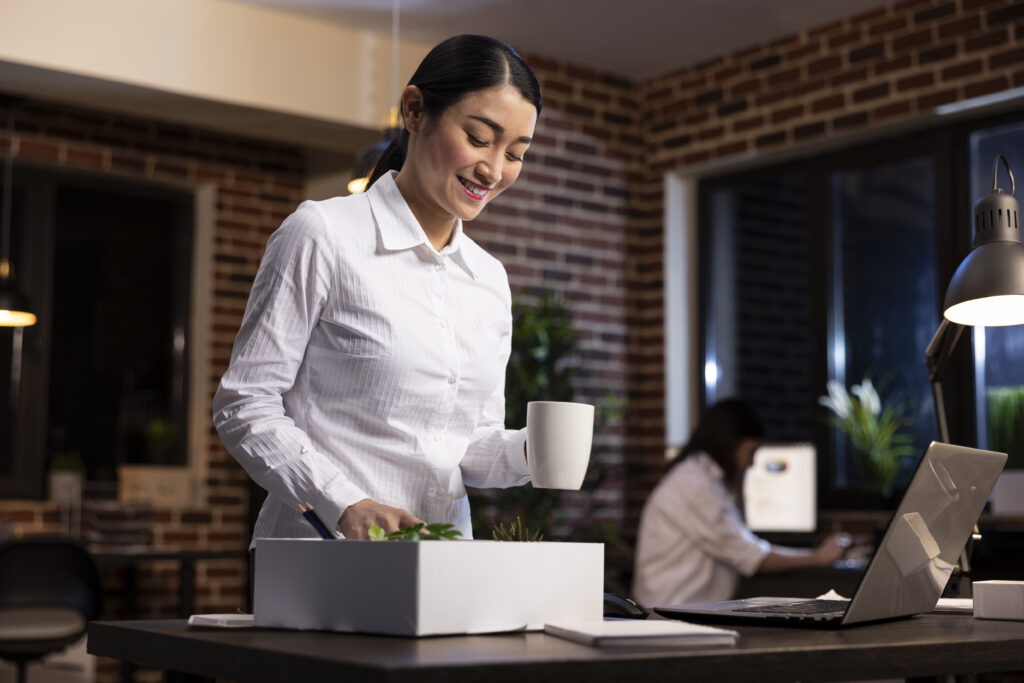 Female employee packing belongings at her desk after resignation