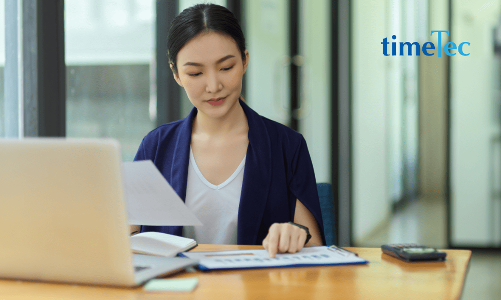 Professional working on documents and data at a desk in a modern office
