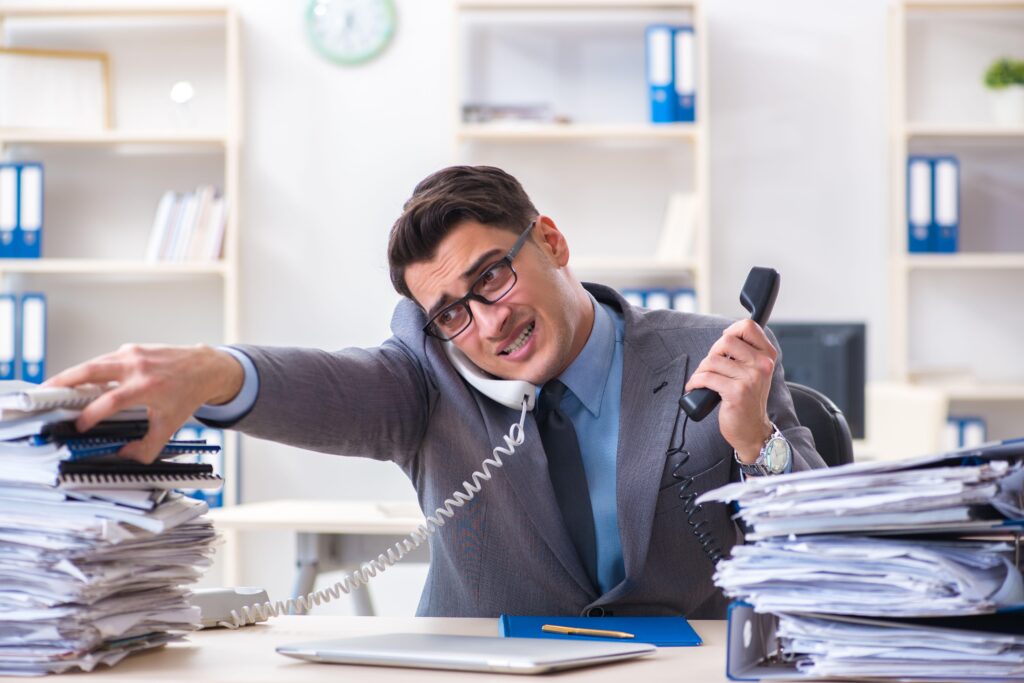 Overworked office staff handling excessive paperwork and documents